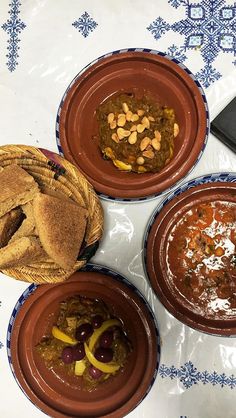 three bowls of food are sitting on a table