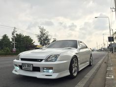 a white sports car is parked on the side of the road