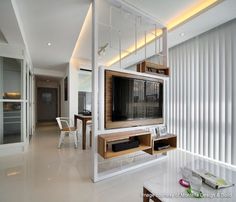 a living room filled with furniture and a flat screen tv on top of a wooden shelf