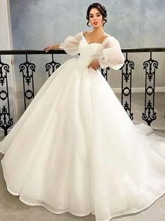 a woman in a white wedding dress standing on a stair railing with her hands on her hips