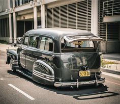 an old car is parked on the side of the road