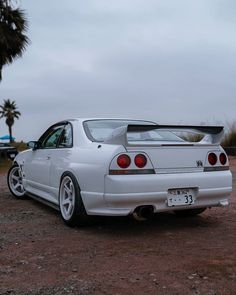 a white car parked on top of a dirt field