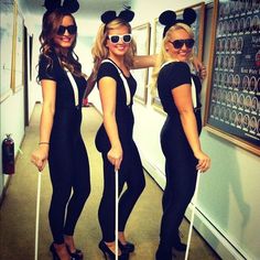 three women dressed in mickey mouse costumes pose for a photo with crutches and canes