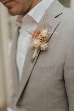 a man wearing a gray suit and flower boutonniere