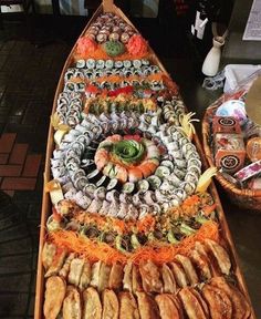 a long boat filled with lots of different types of sushi and other food items