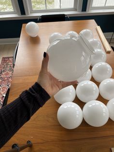 a person is holding a white bowl over some eggs on a table