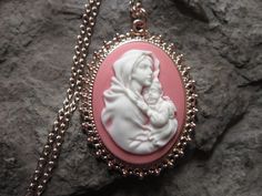 "Wonderful look for Easter and Christmas!! Beautiful Virgin Mary cradling baby Jesus cameo necklaces, choose purple, pink, blue or gray background. The cameos are gorgeous. I do have many other colors, finishes and styles, so please do browse, I can make any larger cameo in my shop into this pretty necklace, so browse and message me with a custom order The pretty setting is classically beautiful rose gold tone, which measures about 2 1/4\" long. The chain is a matching 24\" rose gold link chain Personalized Pink Jewelry For Christmas, Handmade Pink Jewelry For Holiday, Handmade Pink Jewelry For Christmas, Elegant Pink Christmas Jewelry, Pink Cameo Necklace For Gifts, Vintage Pink Necklace For Mother's Day, Pink Cameo Jewelry As A Gift, Handmade Pink Necklace For Mother's Day, Cameo Pendant Necklace