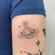 a woman's arm with a tattoo on it that has an image of saturn and stars