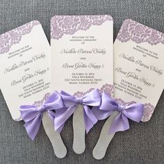 three purple and white wedding programs with bows