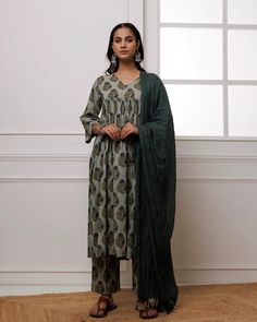 Experience luxury and elegance in our Forest Green Block Printed Suit Set. Crafted from fine mul-mul, this set showcases a classic traditional block print in a deep forest green hue. The set also includes a beautifully complementing dupatta adorned with delicate bead work along its edges. Elevate your wardrobe with this exclusive and timeless piece. No. of pieces - 3 piece set. Color - Green. Fabric - Mul-Mul, Cotton. Washing Instructions - Dry Clean. Festive Green Pant Set With Traditional Drape, Festive Green Traditional Drape Pant Set, Elegant Green Anarkali Set For Transitional Season, Green Palazzo Set With Printed Motifs, Traditional Green Pant Set With Drape, Elegant Green Palazzo Set With Traditional Drape, Green Traditional Drape Pant Set For Eid, Traditional Drape Green Pant Set For Eid, Festive Green Long Sleeve Pant Set