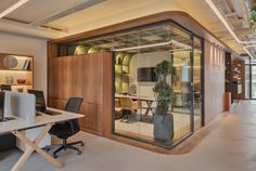 an office with glass walls and wooden accents