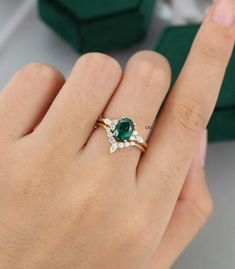 a woman's hand with a ring on it and an emerald in the middle