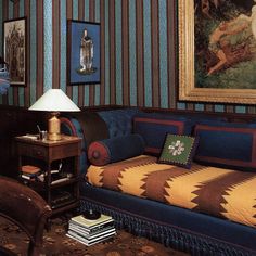 a living room filled with furniture and paintings on the wall next to a table lamp