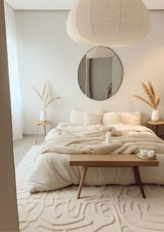 a bedroom with a bed, mirror and table in it