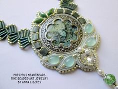 a necklace with green and white beads on it's side, featuring a portrait