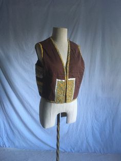 "vintage 1970s handmade patchwork vest quilted calico patterns and polka dots ribbon detail no tags, cotton/polyester feel multi color w/browns and yellow prominent open front good vintage condition, light wear no size tag, fits most like a large, see below measures, lying flat, shoulder-15 1/2\" chest-21\" length-18 3/4\"" Retro Brown Cotton Vest, Cotton Patchwork Vest For Festivals, Retro Multicolor Cotton Vest, Retro Cotton Patchwork Vest, Vintage Brown Cotton Vest, Orange Puffer Jacket, Polka Dot Vest, Vest Quilted, Patchwork Vest