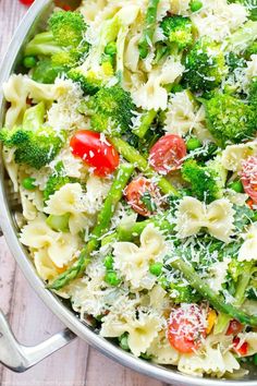 pasta with broccoli, tomatoes and parmesan cheese in a skillet