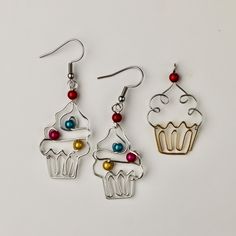 three pairs of earrings with cupcakes on them