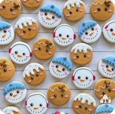 many decorated cookies are arranged in the shape of snowman and snowwoman faces on a white surface