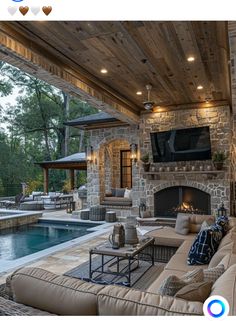 an outdoor living area with fireplace, couches and television on the wall next to a swimming pool