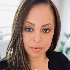 a close up of a woman with long hair and brown eyes looking at the camera