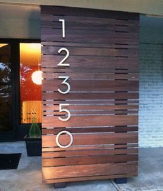 a wooden sign with numbers on it in front of a building