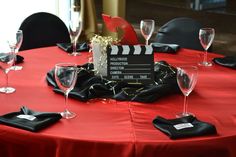 a red table topped with wine glasses and a clapa board