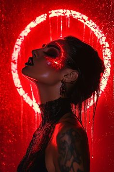 a woman with dark hair and piercings standing in front of a red background