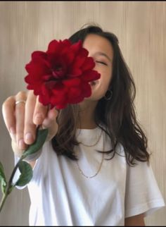 a woman holding a flower up to her face