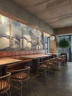 a restaurant with wooden tables and chairs in front of large pictures on the wall behind them