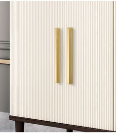 a white cabinet with two gold handles on it