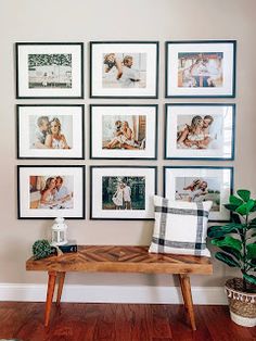 a wooden bench sitting in front of a wall with pictures on it