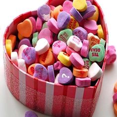 a heart shaped box filled with conversation hearts