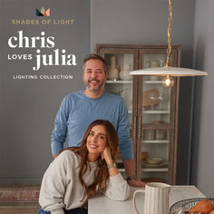 a man and woman standing in front of a kitchen counter with a light hanging from the ceiling