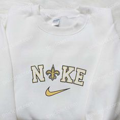 New Orleans Saints x Nike Embroidered Shirt, NFL Sports Embroidered Hoodie, Best Fandom Gift Ideas Nestled in the heart of the bustling streets of New Orleans, Tinicloset emerges as a vibrant beacon of style, offering a haven for fashion enthusiasts and sports aficionados alike. Here, amidst the rhythmic beats of jazz and the tantalizing scent of Cajun cuisine, customers are greeted by a kaleidoscope of custom embroidered apparel, each piece meticulously crafted to embody the essence of elegance Embroidered Apparel, Nfl Sports, Embroidered Clothes, Embroidered Hoodie, New Orleans Saints, Great Love, Embroidered Shirt, Small Gifts, New Orleans