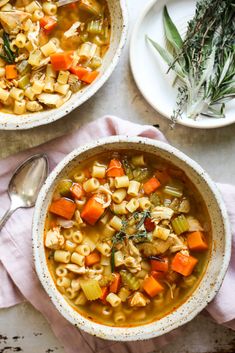 two bowls of chicken noodle soup on a table