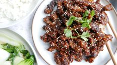 a white plate topped with meat covered in sauce and garnished with cilantro