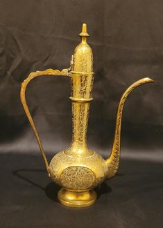 an antique brass tea pot with a handle