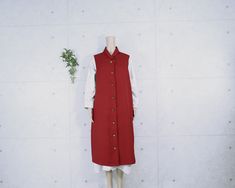 This stylish long vest is made of plain Oni-shibori Chirimen Kimono fabric. A small loofah collar is used for the vest, and handmade buttons give it a solid look. On the back, the kamon (family crest) is attached, cut out from kimono fabric. The kamon, which is meant to protect the members of the family, adds a sense of coolness. Overall, it is a graceful piece of clothing that exudes a calm and mature atmosphere. This listing is for the vest only. The one-piece dress and other items in the photo are not included. Size(inch) Length 43.3 Chest 47.2 Shoulder width 3.9 Back shoulder width 15.7 Armhole 23.6 Sleeve length(CB) - Notes Measurements are taken on a flat surface. Sleeve length(CB) is from the center of the base of the back of the neck to the cuff. Please note that there may be a sli Red Sleeveless Vest With Buttons, Handmade Buttons, Long Vest, Kimono Fabric, Long Vests, Vintage Kimono, Back Shoulder, One Piece Dress, Family Crest