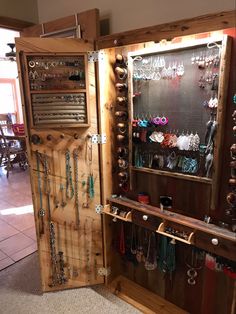 a wooden display case filled with lots of necklaces and jewelry hanging from it's sides