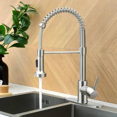 a stainless steel kitchen sink with faucet and soap dispenser next to it