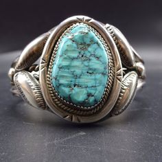 "VINTAGE NAVAJO BRACELET DESCRIPTION: This impressive cuff features a gorgeous specimen of Carico Lake turquoise. The gemstone is secure in sawtooth bezel, on a foundation of heavy gauge vintage sterling silver. A heavy braided band of sterling silver bisects the hand-stamped carinated cuff, and stamped and repousse ovals frame the gemstone. This spectacular bracelet will be a cherished addition to your collection of fine vintage Native American jewelry. MEASUREMENTS: Interior of the cuff measur Vintage Patina Cuff Bracelet, Vintage Cuff Bracelets For Collectors, Vintage Cuff Bracelets Collectible, Classic Handmade Cuff Bracelet Collectible, Collectible Vintage Cuff Bracelet, Vintage Cuff Bracelet With Patina, Vintage Turquoise Cuff Bracelet, Vintage Native American Jewelry, Navajo Bracelet