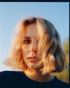 a woman with blonde hair looking at the camera