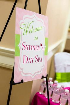 a welcome sign for sydney's day spa is hanging from the wall next to bottles of water