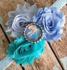 a blue flower with a frozen princess photo on it's center piece, sitting on top of a wooden table