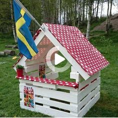 a house made out of wooden pallets with a flag on top