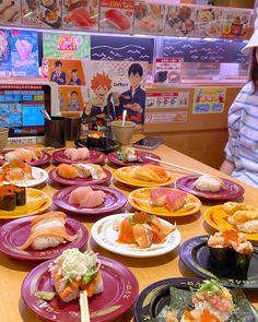 a woman sitting at a table with many plates of food