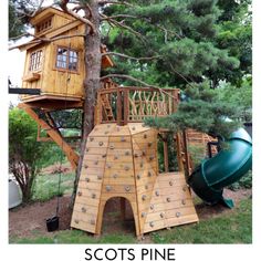 there is a wooden play set in the yard with a slide and tree house on it