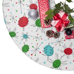 a table with wrapping and christmas decorations on it, next to a potted plant