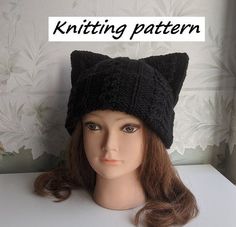 a knitted black cat hat on top of a mannequin's head